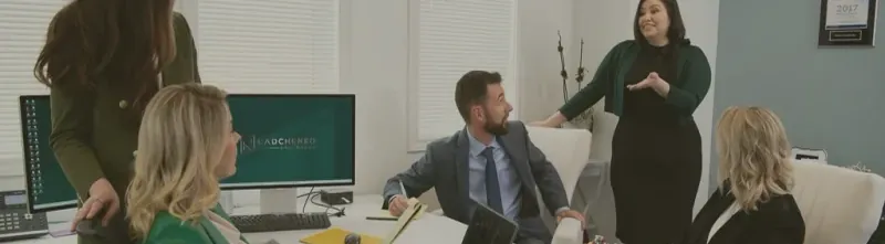 A small group talking around a desk in a bright office